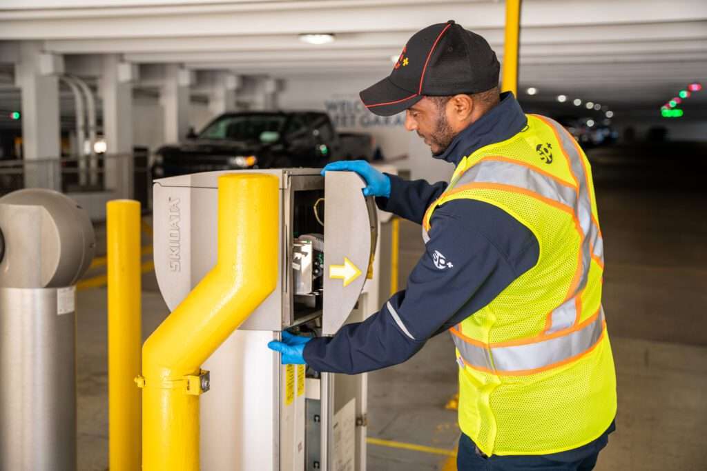 SP+ facility maintenance worker fixing parking equiptment